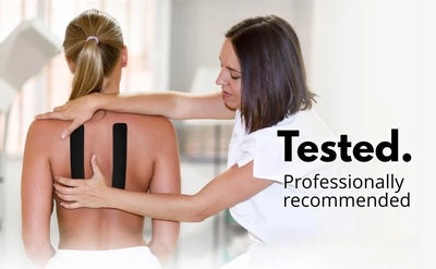 Physical therapist applying kinesio tape on a patient's back for muscle recovery and pain relief.