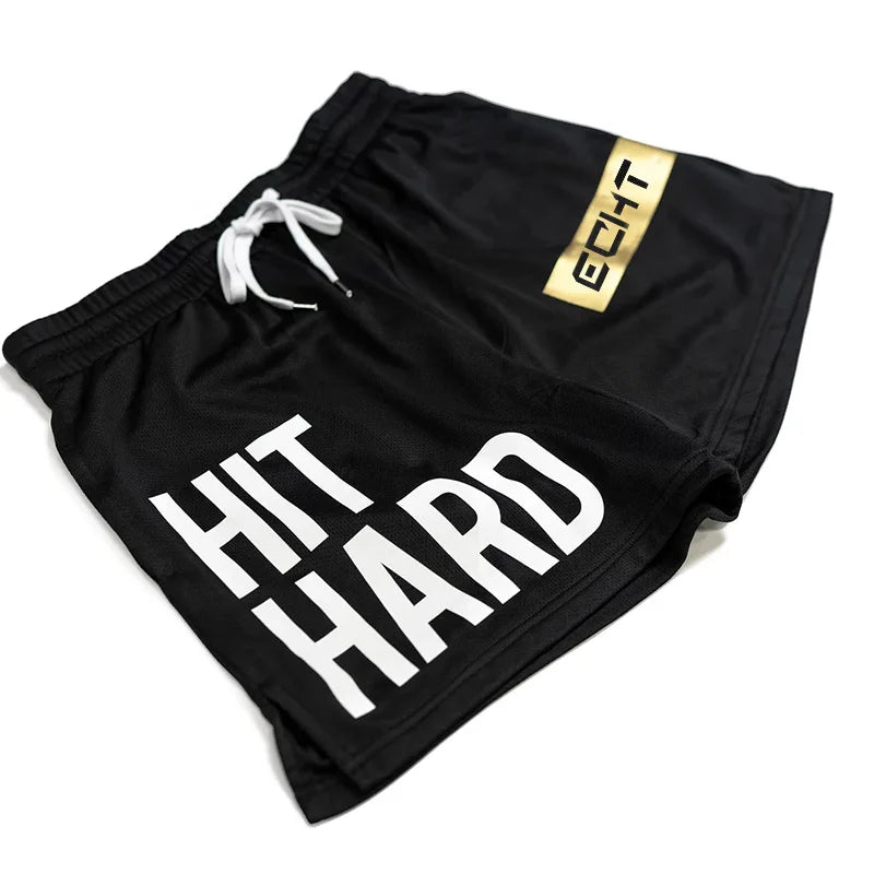 Men's black gym shorts with white 'HIT HARD' print and gold accent, lightweight, breathable sportswear for workouts.
