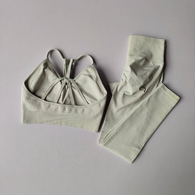 Seamless women's yoga set featuring a V-neck bra and hip-lift leggings in light gray, perfect for fitness and toning.