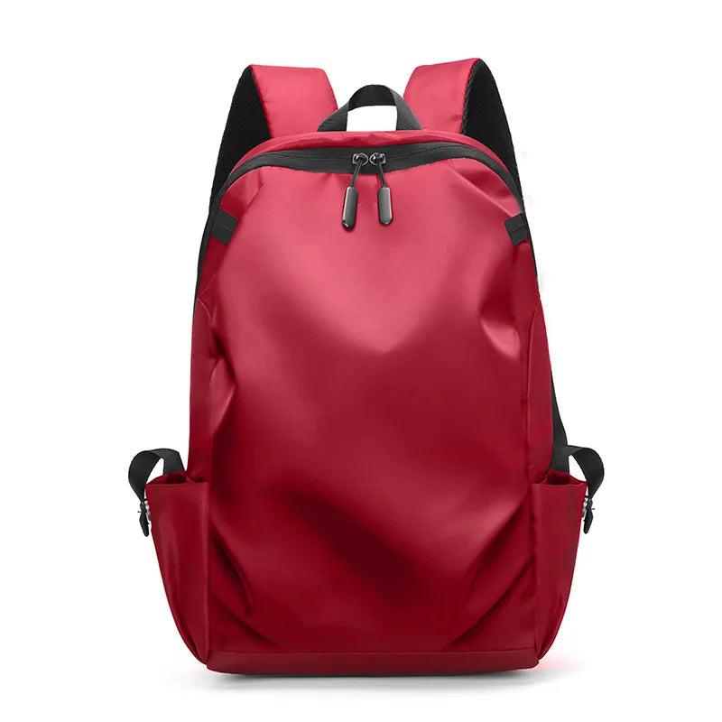 Red unisex backpack with zipper closure, soft straps, and multiple compartments for students and travelers.