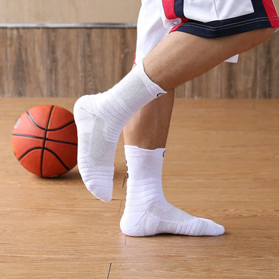 Man wearing breathable elastic compression sports socks while playing basketball on a wooden court.