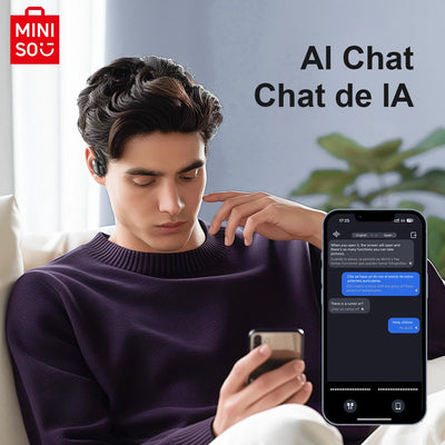 Young man using MINISO MS162 Bluetooth earbuds while chatting on smartphone, showcasing AI chat feature.